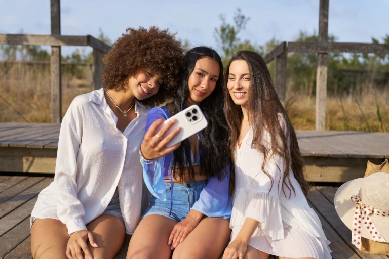 Three women sitting taking a selfie